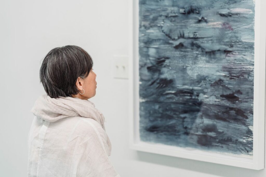 A woman looking at an abstract painting in a modern art gallery.